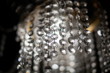 Glass elements transmit light from lamps. A chandelier spreads light through repeating wands. Cold...