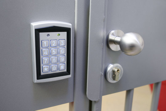 Closeup Of Electronic Lock With Keypad  And Steel Bobble Handle On Metal Bar Security Door