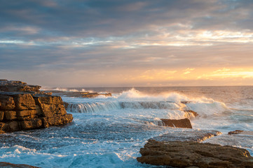 Ocean coastline scene with waves crushing over rocks