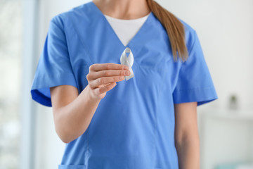 Female doctor with Parkinson's awareness ribbon in clinic, closeup