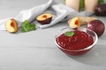 Bowl with plum sauce on table