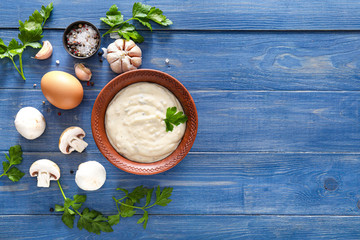 Bowl with mushroom sauce and ingredients on table