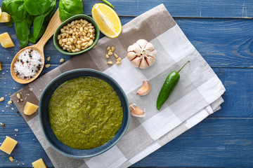 Bowl with pesto sauce and ingredients on table