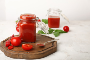 Jar with tomato sauce on white background