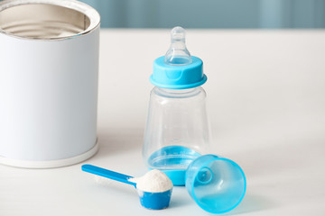Bottle with baby milk formula on table indoors