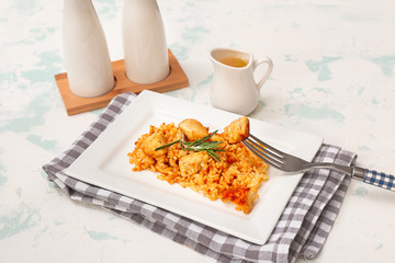 Plate with tasty rice and chicken on white background