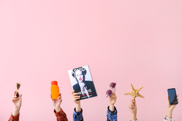 Many hands with travel items on color background