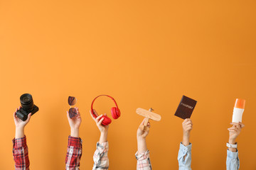 Many hands with travel items on color background - obrazy, fototapety, plakaty