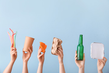 Hands with garbage on color background. Concept of recycling