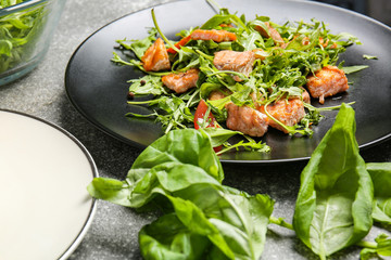 Plate with tasty salmon salad on table