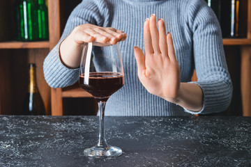 Woman refusing to drink wine in bar. Concept of alcoholism