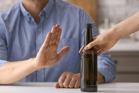 Man refusing to drink beer at home. Concept of alcoholism