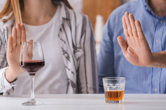 Couple refusing to drink wine and whiskey. Concept of alcoholism