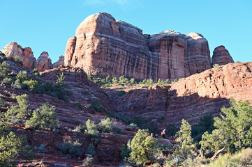 Distant hikers on Cathedral Rock Trail near Sedona, Arizona in early morning on clear winter day.