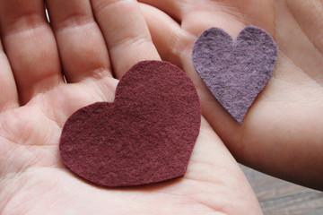 Felt textile hearts for Saint Valentine day on 14 of February in the palm of the hand, symbol of...