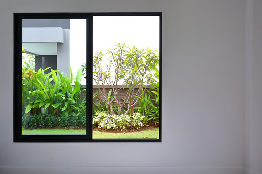 Fototapeta slide glass window on white wall interior in modern empty room with small garden landscaping outside a new house