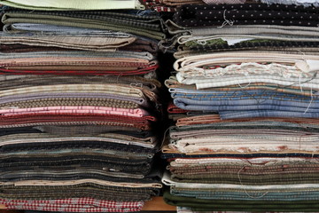 stack of pieces fabric many pattern on shelf, material recycle for clothing fashion design