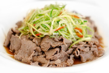 Chinese style fried beef topped with green fresh vegetable