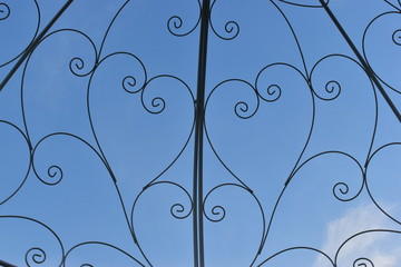 heart shape of curve steel wire in outdoor garden decoration with blue sky background