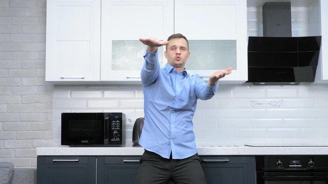 young handsome man dancing in the kitchen. lifestyle