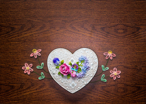 Handcraft heart shape box with decoration of flowers on wooden background for Happy Valentine's Day