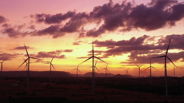 Aerial view of Wind turbines of save Energy save world in B roll footage. aerial shot on sunset. drone footage wind turbines at sunrise with beautiful clouds. Global warming concept and green energy.