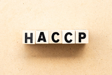 Letter block in word HACCP (Hazard Analysis Critical Control Points) on wood background