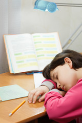 Young schoolgirl fell asleep at school homework.