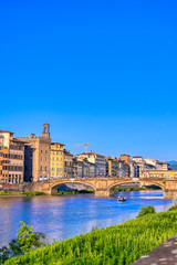 Obraz premium A view of the Arno River towards the Ponte Vecchio in Florence, Italy.