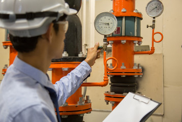 Engineer checking Condenser Water pump and pressure gauge , chiller water pump with pressure gauge.