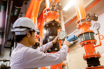 Engineer checking Condenser Water pump and pressure gauge , chiller water pump with pressure...