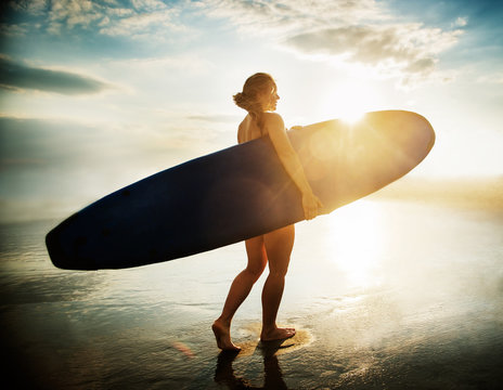 surfer with her surfboard on the beach