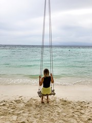 girl on a swing on the beach