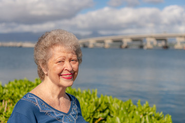 Fototapeta na wymiar A beautiful senior woman poses for a portrait while on a family trip in Hawaii.