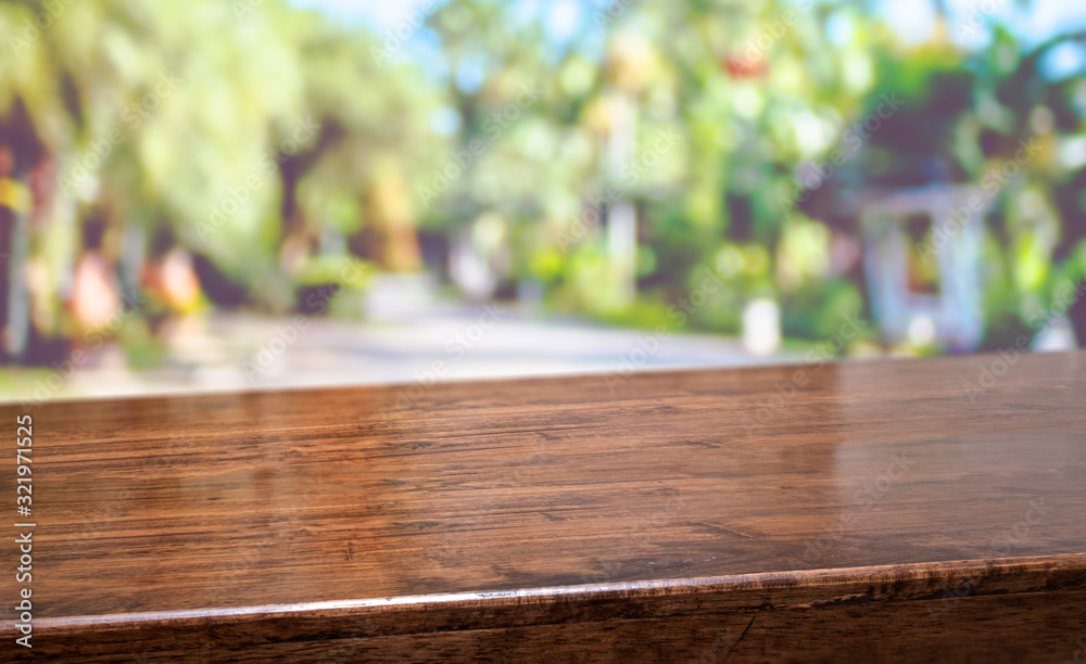 Poster tropical spring background.empty diagonal brown wooden table with blur tree in park boekh background