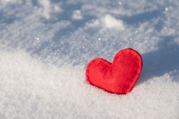 Fototapeta premium Red hearts in glittering snow with shallow depth of field