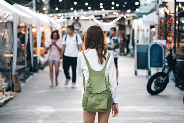 Asian woman sightseeing at vintage street night market.