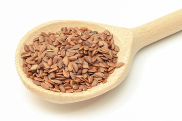 Linseed with wooden spoon. White background. Healthy food containing dietary fiber