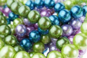 colored pearls close-up. pearl beads round background.blue, purple, green and pink beads texture.Beautiful decoration background 