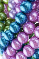  pearls close-up. pearl beads round background.blue, purple, green and pink beads texture.Beautiful decoration background in cold colors.
