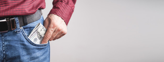 Man putting dollars into the pocket.