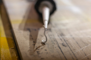 Glue is squeezed out of a tube. Glue in the workshop. Tool for traction surfaces. The rubber material flows out of the spout of the container.