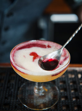 Champagne cocktail with red wine floater being made