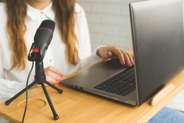 Girl records a podcast with a microphone at home. Modern technologies for creating content for...