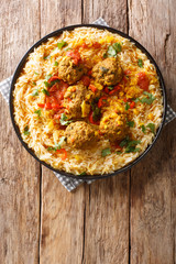 Kofta Challow is one of the ethnic Afghan dishes consisting of meat balls in a spicy sauce served with basmati rice  close-up in a plate. Vertical top view