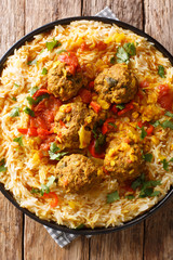 Kofta Chalao. Sauteed meatballs simmered in a blend of Afghan spices, garlic and onions, served with Basmati rice close-up in a plate. Vertical top view