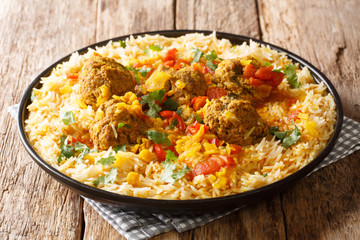Kofta Chalao Recipe for Afghan meatballs in spicy sauce with yellow peas served with basmati rice close-up in a plate. horizontal