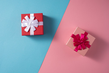 Valentine's Day celebration concept. A nice gift for your loved one. Boxes with bows on delicate blue and pink backgrounds. Copy space. Flat lay. Close-up.