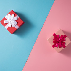 Valentine's Day celebration concept. A nice gift for your loved one. Boxes with bows on delicate blue and pink backgrounds. Copy space. Flat lay. Close-up.