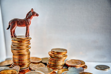 donkey on top of column of stacked coins